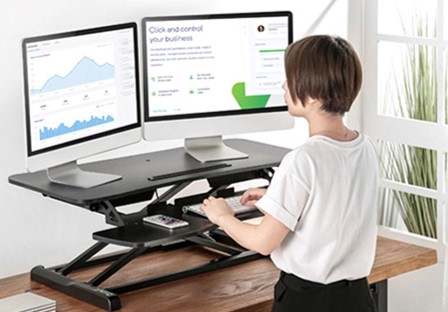 Commercial sit-stand desk riser setup used prior to the custom solution